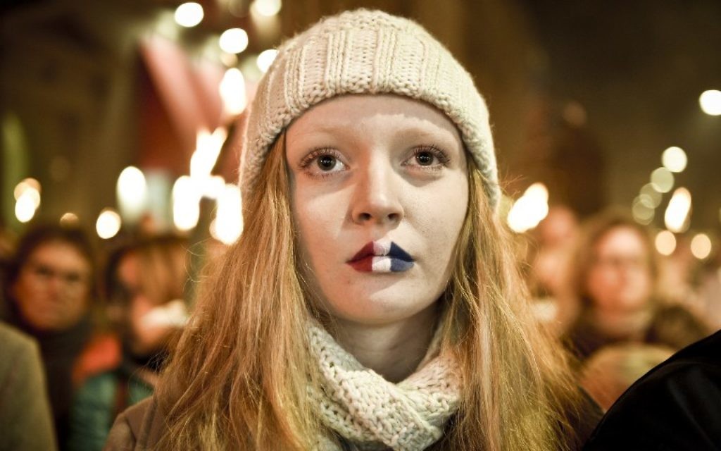 Une fille avec les lèvres peintes en drapeau tricolore français assiste à une veillée à la mémoire des victimes de Paris en face de l'ambassade française le 15 novembre 2015 à Copenhague. (Crédit : AFP PHOTO / Nils Meilvang / SCANPIX DANEMARK / NILS MEILVANG +++ DANEMARK OUT)