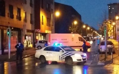 Une photo prise avec un  téléphone portable le 14 novembre 2015 montre une camionnette de l'unité belge de déminage SEDEE tandis que les policiers bloquent une rue lors d'un raid de la police dans le quartier de Molenbeek à Bruxelles, peut-être en relation avec les attentats meurtriers du 13 novembre à Paris (Crédit : AFP Photo / Belga / Hendrik Devriendt)
