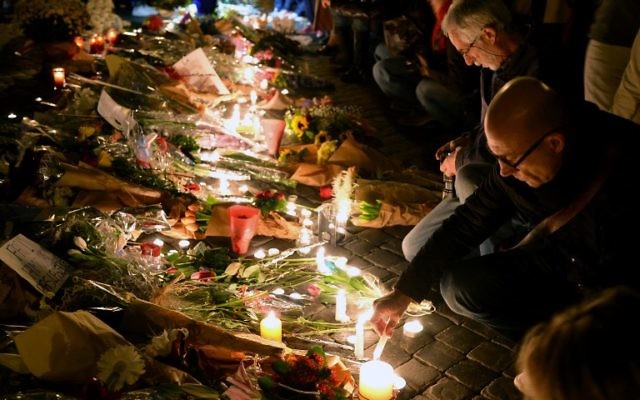 Les gens allument des bougies et déposent des fleurs, le 14 novembre, 2015 au mémorial de fortune devant l'ambassade française à Rome après une série d'attaques coordonnées dans et autour de Paris le 13 novembre (Crédit : AFP PHOTO / VINCENZO PINTO) Les gens allument des bougies et déposent des fleurs, le 14 novembre, 2015 au mémorial de fortune devant l'ambassade française à Rome après une série d'attaques coordonnées dans et autour de Paris le 13 novembre (Crédit : AFP PHOTO / VINCENZO PINTO)