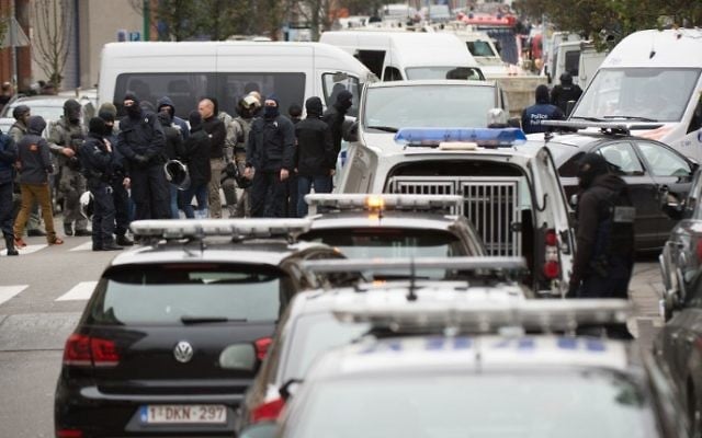 Les forces de sécurité du personnel pendant une opération dans le quartier de Molenbeek à Bruxelles le 16 novembre 2015. La police belge a lancé une nouvelle opération majeure dans le quartier de Molenbeek à Bruxelles, où plusieurs suspects dans les attentats de Paris avaient déjà vécu, le 16 novembre (Crédit ; AFP PHOTO / BELGA PHOTO immédiate / BENOIT DOPPAGNE)