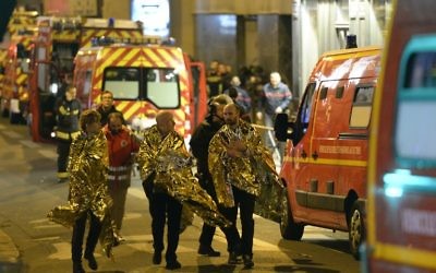 Les gens sont évacués de la rue Oberkampf à proximité de la salle de concert du Bataclan à Paris, le 14 novembre 2015. (Crédit : AFP PHOTO / MIGUEL MEDINA)