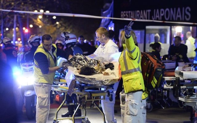 Les secouristes évacuent un blessé près de la salle de concert Le Bataclan à Paris, le 14 novembre 2015 (Crédit : Miguel Medina/AFP)