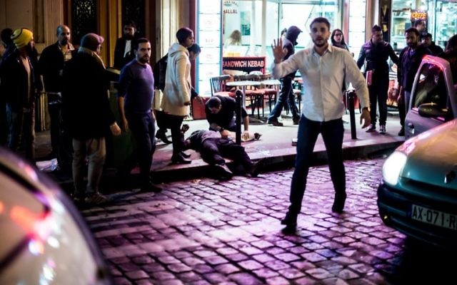 Un homme est allongé sur le trottoir près du café Bonne Biere à Paris, le 13 novembre 2015, suite à une série d'attaques coordonnées dans et autour de Paris, qui ont fait plus de 120 morts (Crédit : AFP PHOTO / ANTHONY DORFMANN)