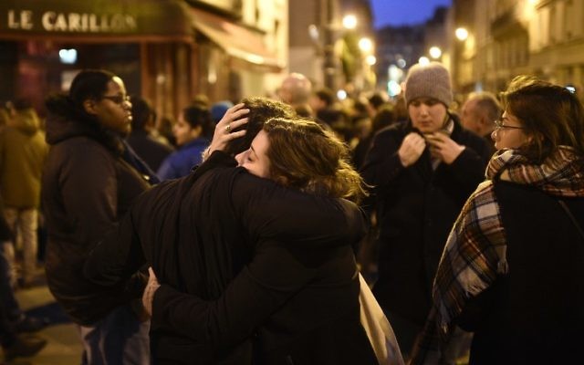 Rassemblement près du restaurant Le Carillon, l'un des sites des attentats à Paris, le 14 novembre 2015. Au moins 128 personnes ont été tuées dans les attentats de Paris qui ont eu lieu pendant la soirée du 13 novembre, avec 180 personnes blessées (Crédit : Martin Bureau/AFP)