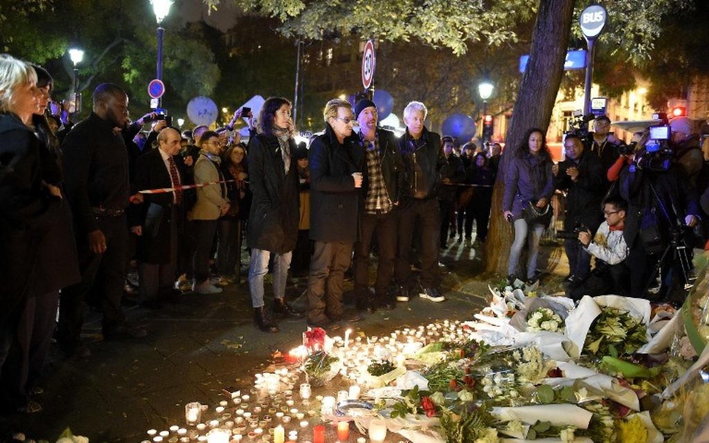 De Gauche à droite : Bono de U2, le guitariste The Edge, le batteur Larry Mullen Jr et le bassiste Adam Clayton rendant hommage aux victimes de attaques près de la salle de concert au Bataclan le 14 novembre 2015 Paris, un jour après une série de coordonnées attaques dans et autour de Paris (Crédit : AFP PHOTO / FRANCK FIFE)