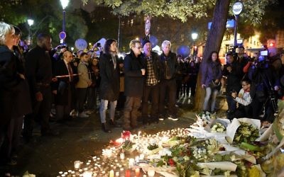 De Gauche à droite : Bono de U2, le guitariste The Edge, le batteur Larry Mullen Jr et le bassiste Adam Clayton rendant hommage aux victimes de attaques près de la salle de concert au Bataclan le 14 novembre 2015 Paris, un jour après une série de coordonnées attaques dans et autour de Paris (Crédit : AFP PHOTO / FRANCK FIFE)