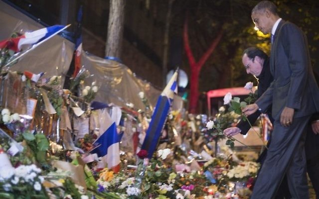 Le président américain Barack Obama avec le président français François Hollande  devant un mémorial à l'extérieur du Bataclan, à Paris, le 30 novembre 2015. (Crédit : Jim Watson/AFP)