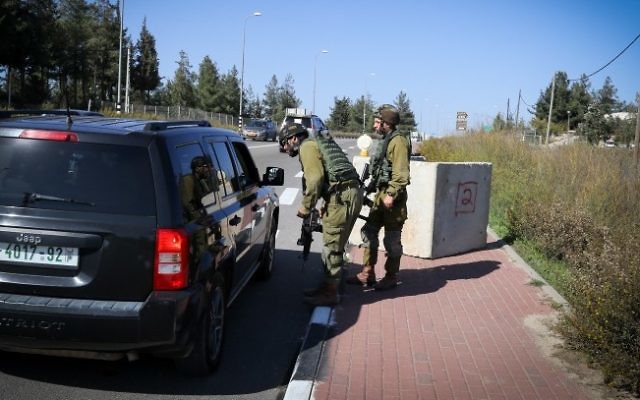 Des soldats de Tsahal inspectant un véhicule palestinien à un checkpoint temporaire mis en place près d'Alon Shvut, au Gush Etzion en Cisjordanie le 22 novembre 2015 (Crédit : Gershon Elinson / FLASH90) Des soldats de Tsahal inspectant un véhicule palestinien à un checkpoint temporaire mis en place près d'Alon Shvut, au Gush Etzion en Cisjordanie le 22 novembre 2015 (Crédit : Gershon Elinson / FLASH90)