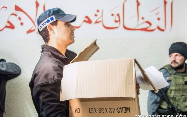 Un agent de police israélien participant à une perquisition dans les bureaux de la branche nord du Mouvement islamique lundi 16 novembre 2015 (Crédit : Police israélienne) Un agent de police israélien participant à une perquisition dans les bureaux de la branche nord du Mouvement islamique lundi 16 novembre 2015 (Crédit : Police israélienne)