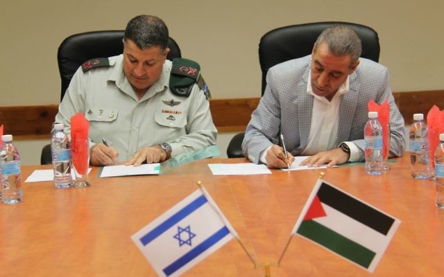 Le ministre palestinien des affaires civiles, Hussein al-Sheikh, à droite, et le coordinateur israélien des activités gouvernementales dans les territoires (COGAT), le Major Général, Yoav Mordechai, signent un "mémorandum d'accord" qui pourrait ouvrir le service 3G dans les zones palestiniennes en trois à six mois, le 19 novembre 2015 (Crédit : IDF) Le ministre palestinien des affaires civiles, Hussein al-Sheikh, à droite, et le coordinateur israélien des activités gouvernementales dans les territoires (COGAT), le Major Général, Yoav Mordechai, signent un "mémorandum d'accord" qui pourrait ouvrir le service 3G dans les zones palestiniennes en trois à six mois, le 19 novembre 2015 (Crédit : IDF)
