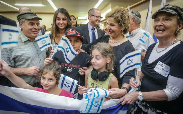 Le président de l'Agence juive, Nathan Sharansky, et la ministre de l'Immigration et de l'Intégration, Sofa Landver, avec une famille arrivant de France en Israël en juillet 2014. (Crédit : David Salem)