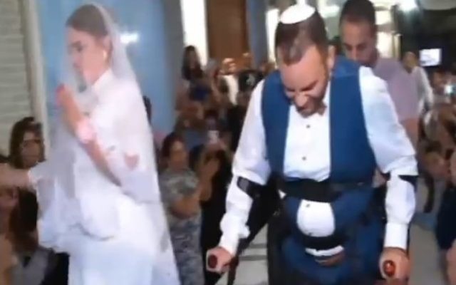Avec l'aide de ReWalk Robotics, Dudu Shevy a pu marcher vers le dais nuptial (Capture d'écran: Deuxième chaîne) Avec l'aide de ReWalk Robotics, Dudu Shevy a pu marcher vers le dais nuptial (Capture d'écran: Deuxième chaîne)