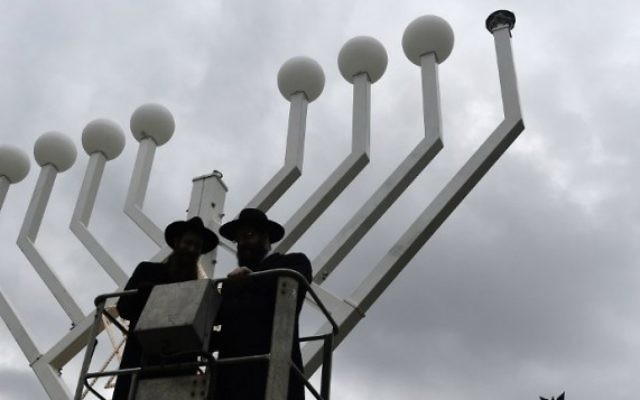 Deux rabbins se dressent sur une plate-forme surélevée où un géant candélabre de Hanoucca installé en face de la Porte de Brandebourg à Berlin le 4 décembre, 2015, deux jours avant le début de la fête juive de huit jours. (Crédit : AFP Photo / Tobias Schwarz) Deux rabbins se dressent sur une plate-forme surélevée où un géant candélabre de Hanoucca installé en face de la Porte de Brandebourg à Berlin le 4 décembre, 2015, deux jours avant le début de la fête juive de huit jours. (Crédit : AFP Photo / Tobias Schwarz)