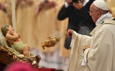 François balance un encensoir en face d'une statue de l'enfant Jésus, alors qu'il célèbre une messe la veille de Noël marquant la naissance de Jésus-Christ le 24 décembre 2015 à la basilique Saint-Pierre au Vatican.(Crédit :  AFP PHOTO / VINCENZO PINTO)