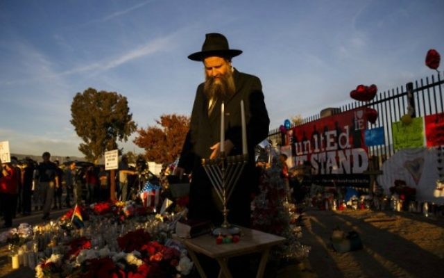 Rabbi Chalom Harlig se prépare à allumer la menorah pour la première nuit de Hanoukka à un mémorial de fortune situé près du Centre régional intérieure à la suite d'un tir de la terreur de masse qui a tué 14 personnes à San Bernardino, en Californie, le 6 décembre, 2015. (Crédit : AFP Photo / Patrick T. Fallon) Rabbi Chalom Harlig se prépare à allumer la menorah pour la première nuit de Hanoukka à un mémorial de fortune situé près du Centre régional intérieure à la suite d'un tir de la terreur de masse qui a tué 14 personnes à San Bernardino, en Californie, le 6 décembre, 2015. (Crédit : AFP Photo / Patrick T. Fallon)