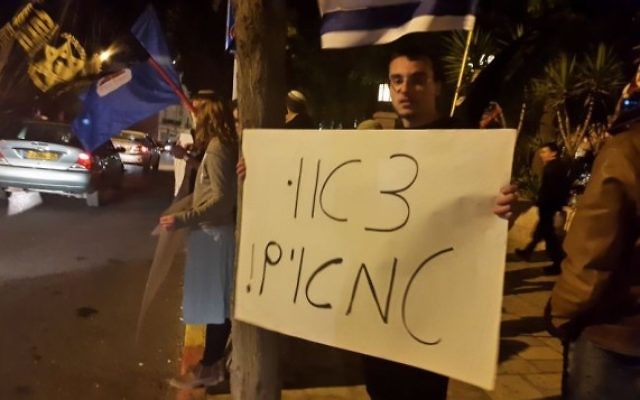 Un manifestant de Lehava porte une pancarte où l'on peut lire : "Partez, impurs," lors d'une manifestation dénonçant Noël devant le marché du YMCA à Jérusalem, le 29 novembre 2015. (Crédit : Times of Israel)
