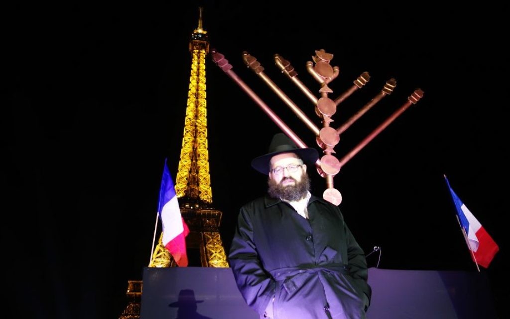 Le rabbin Mendel Azimov, président du Chabad de Paris, allume la ménorah de Hanoukka de vant la Tour Eiffelle 6 décembre 2015. (Crédit : Greg Scruggs/The Times of Israel)
