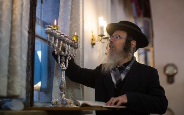 Un homme juif ultra-orthodoxe allume des bougies pour la fête juive de Hanoukka dans le quartier de Mea Shearim à Jérusalem le 6 décembre, 2015. (Yonatan Sindel / Flash90) Un homme juif ultra-orthodoxe allume des bougies pour la fête juive de Hanoukka dans le quartier de Mea Shearim à Jérusalem le 6 décembre, 2015. (Yonatan Sindel / Flash90)