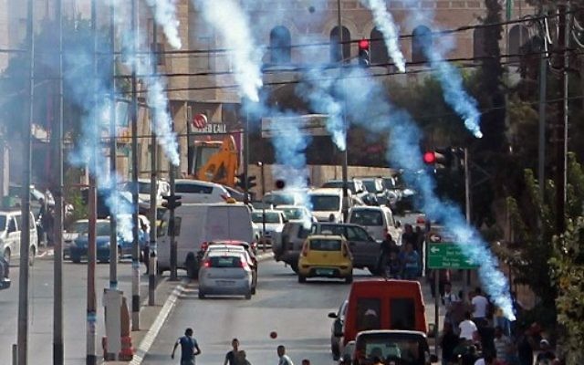 Des manifestants palestiniens se mettent à l'abri à du gaz lacrymogène lancé par les forces de sécurité israéliennes lors d'affrontements dans la ville de Bethléem en Cisjordanie, le 2 octobre 2015 (Crédit photo: Musa al Shaer / AFP) Des manifestants palestiniens se mettent à l'abri à du gaz lacrymogène lancé par les forces de sécurité israéliennes lors d'affrontements dans la ville de Bethléem en Cisjordanie, le 2 octobre 2015 (Crédit photo: Musa al Shaer / AFP)
