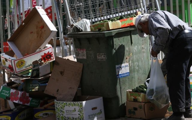 Un vieil homme cherchant parmi les ordures près du marché dans la ville israélienne de Petah Tikva,  le 24 juin 2015 (Crédit : Nati Shohat / Flash90)