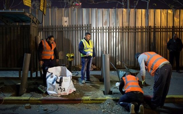Des ouvriers israéliens et palestiniens placent des poteaux à un arrêt d'autobus à Jérusalem le 20 décembre 2015, après une attaque terroriste qui a eu lieu la semaine dernière (Crédit photo: Yonatan Sindel / Flash90) Des ouvriers israéliens et palestiniens placent des poteaux à un arrêt d'autobus à Jérusalem le 20 décembre 2015, après une attaque terroriste qui a eu lieu la semaine dernière (Crédit photo: Yonatan Sindel / Flash90)