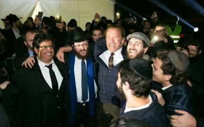 L'ancien gouverneur de Californie Arnold Schwarzenegger danse avec les rabbins Loubavitch à une cérémonie d'allumage de menorah publique au pied de la Tour Eiffel à Paris, le dimanche 6 décembre, 2015, la première nuit de la fête de huit jours. (Crédit : chabad.org/Thierry Guez) L'ancien gouverneur de Californie Arnold Schwarzenegger danse avec les rabbins Loubavitch à une cérémonie d'allumage de menorah publique au pied de la Tour Eiffel à Paris, le dimanche 6 décembre, 2015, la première nuit de la fête de huit jours. (Crédit : chabad.org/Thierry Guez)
