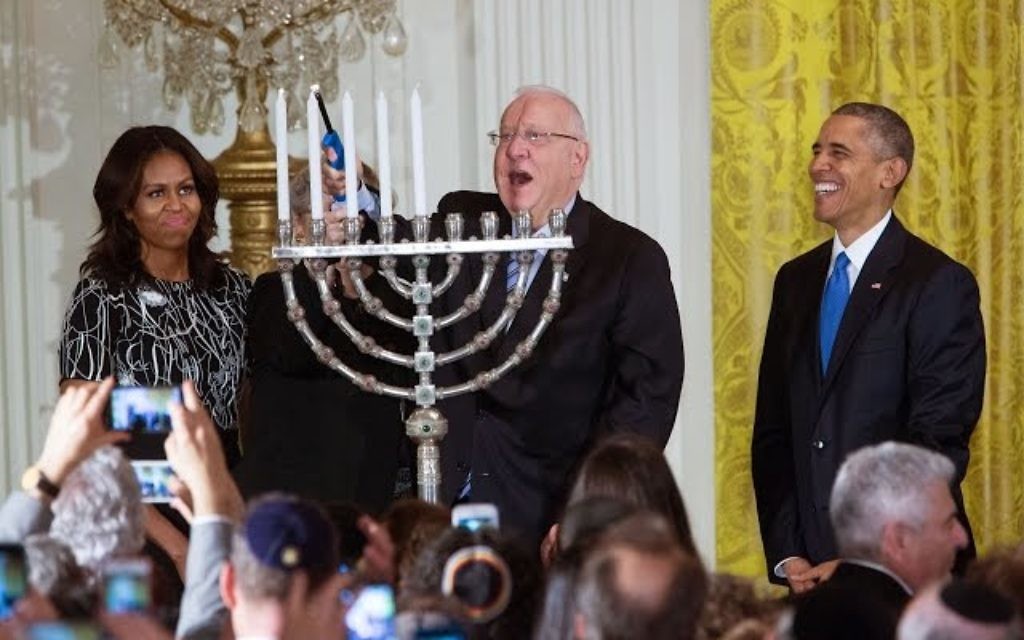 Le président Reuven Rivlin allume la menorah de Hanoukka , en présence du président américain Barack Obama, de Michelle Obama, et de Nechama Rivlin, à la Maison Blanche, le 9 décembre 2015. (Crédit : capture d'écran YouTube/The White House) Le président Reuven Rivlin allume la menorah de Hanoukka , en présence du président américain Barack Obama, de Michelle Obama, et de Nechama Rivlin, à la Maison Blanche, le 9 décembre 2015. (Crédit : capture d'écran YouTube/The White House)