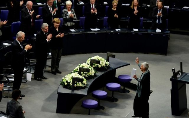 (Rangée de devant) La chancelière allemande Angela Merkel (à droite), le président Joachim Gauck (2ème à droite), le Premier ministre de Saxe Stanislaw Tillich (à gauche) applaudissant la survivante de l'Holocauste, Ruth Kluger, après son discours lors de la Journée internationale de commémoration de l'Holocauste, le 27 janvier 2016 au Parlement allemand à Berlin (Crédit : AFP / John MACDOUGALL)