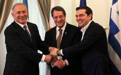 Le président chypriote, Nicos Anastasiades (au centre), le Premier ministre israélien Benjamin Netanyahu (à gauche) et le Premier ministre grec, Alexis Tsipras se serrant la main lors de leur rencontre au palais présidentiel à Nicosie, à Chypre, le 28 janvier 2016 (Crédit : POOL/AFP / Yiannis Kourtoglou)