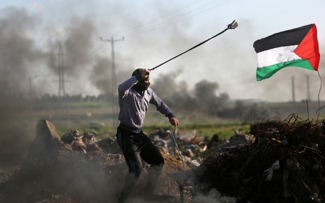 Des manifestants palestiniens ont lancé des pierres sur les forces de sécurité israéliennes lors d'affrontements près de la zone Shajaiya de la ville de Gaza le long de la frontière avec Israël, le 18 décembre 2015 (Crédit : AFP PHOTO / MAHMUD HAMS) Des manifestants palestiniens ont lancé des pierres sur les forces de sécurité israéliennes lors d'affrontements près de la zone Shajaiya de la ville de Gaza le long de la frontière avec Israël, le 18 décembre 2015 (Crédit : AFP PHOTO / MAHMUD HAMS)
