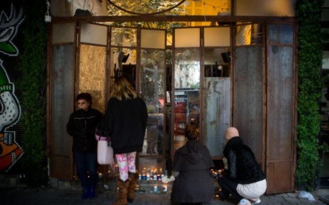 Des Israéliens allument des bougies au bar Simta sur la rue Dizengoff, dans le centre de Tel Aviv, le 2 janvier 2016. (Crédit : Miriam Alster/Flash90)