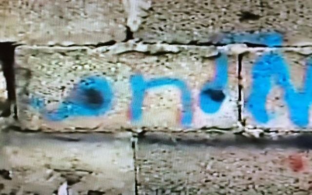 Le nom de famille en hébreu "Milhem" écrit en bleu sur le mur extérieur du dernier bâtiment dans lequel le tireur de Tel Aviv, Nashat Milhem, s'est caché à Arara avant d'être retrouvé, pourchassé et tué le 8 janvier 2016. (Crédit : capture d'écran Deuxième chaîne) Le nom de famille en hébreu "Milhem" écrit en bleu sur le mur extérieur du dernier bâtiment dans lequel le tireur de Tel Aviv, Nashat Milhem, s'est caché à Arara avant d'être retrouvé, pourchassé et tué le 8 janvier 2016. (Crédit : capture d'écran Deuxième chaîne)