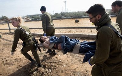 Un adolescent palestinien blessé, suspecté d'avoir poignardé une femme enceinte dans l'implantation de Tekoa, est évacué sur une civière par les soldats israéliens le lundi 18 janvier 2016. (Crédit : AFP/MENAHEM KAHANA)