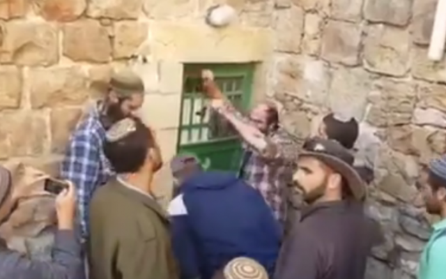 Des résidents d'implantations entrant par la force le 21 Janvier 2016 à Hébron dans des propriétés qu'ils prétendent avoir secrètement achetées (Capture d'écran YouTube)