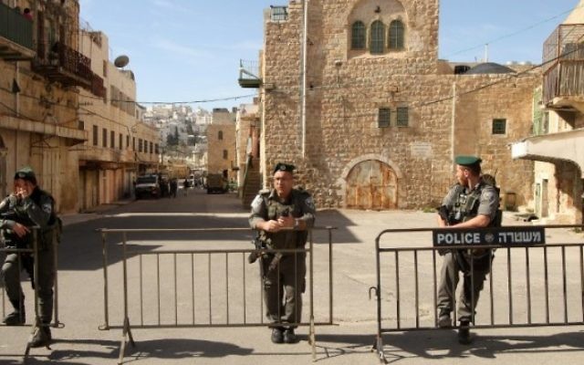Des garde-frontières devant les deux maisons d'où des résidents juifs ont été évacués à Hébron, le 22 janvier 2016. (Crédit : Hazem Bader/AFP) Des garde-frontières devant les deux maisons d'où des résidents juifs ont été évacués à Hébron, le 22 janvier 2016. (Crédit : Hazem Bader/AFP)