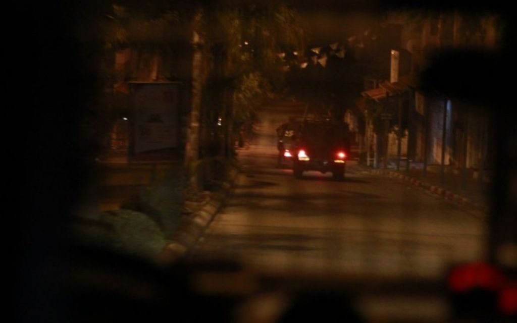 Une jeep de l’armée israélienne à Qalqilya le 14 janvier 2016. Alors que le véhicule militaire quitte la ville, certains résidents lui jettent des pierres, sans causer aucun dommage. Les trois suspects arrêtés par le bataillon Tigre seront remis aux forces de l’ordre plus tard ce matin-là. (Crédit : Judah Ari Gross/Times of Israel)