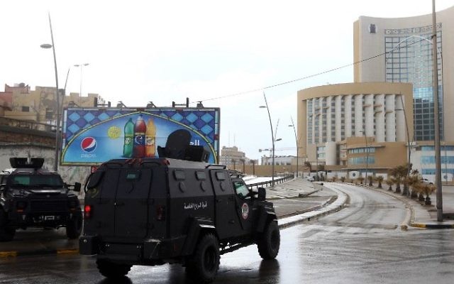 Les services de sécurité et d'urgence de la Libye entoure l'hôtel Corinthia de Tripoli (à droite), attaqué par des combattants de l'Etat islamique, le 27 janvier 2015. (Crédit : AFP/Mahmud Turkia) Les services de sécurité et d'urgence de la Libye entoure l'hôtel Corinthia de Tripoli (à droite), attaqué par des combattants de l'Etat islamique, le 27 janvier 2015. (Crédit : AFP/Mahmud Turkia)