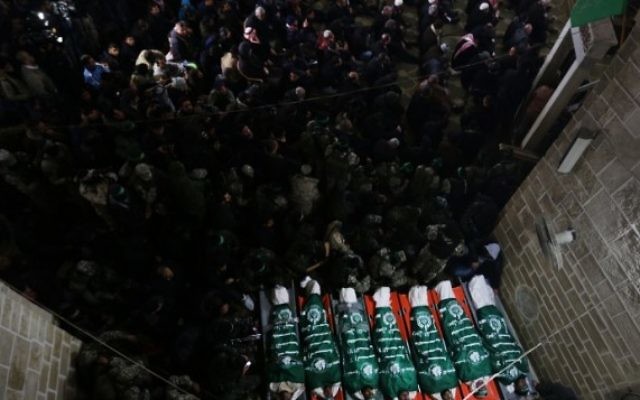 Des combattants du Hamas se rassemblent autour des corps de sept ouvriers tués dans l'effondrement d'un tunnel dans la bande de Gaza, pendant leurs funérailles, le 29 janvier 2016. (Crédit : AFP/Mahmud Hams) Des combattants du Hamas se rassemblent autour des corps de sept ouvriers tués dans l'effondrement d'un tunnel dans la bande de Gaza, pendant leurs funérailles, le 29 janvier 2016. (Crédit : AFP/Mahmud Hams)