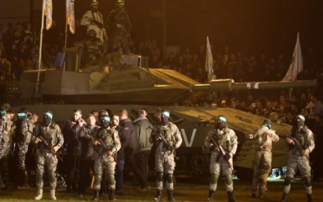 Des membres palestiniens de la branche armée du Hamas rassemblés autour d'un faux char israélien le 31 janvier 2016, en hommage aux Gazaouis morts dans l'effondrement d'un tunnel. (Crédit : AFP / MAHMUD HAMS)