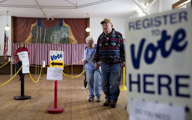 Un homme et une femme américains viennent de voter à Chichester, New Hampshire. le 9 février 2016 (Crédit : DOMINICK REUTER / AFP)