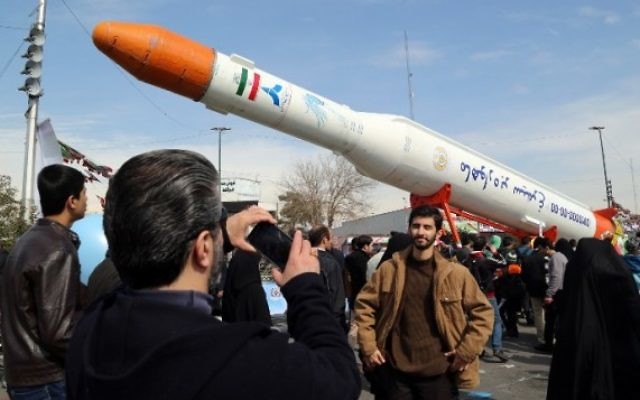 Des Iraniens prennent des photos d'une réplique de la fusée Simorgh, capable de lancer des satellites, pendant les célébrations du 37ème anniversaire de la République islamique, à Téhéran, le 11 février 2016. (Crédit : AFP/Atta Kenare)