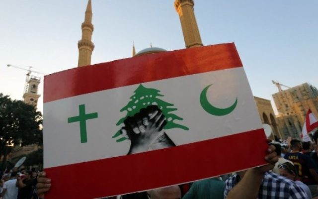 Un manifestant libanais brandit un panneau pendant un rassemblement de masse contre la classe politique perçue comme corrompue et incapable de fournir les services élémentaires, sur l’iconique place des Martyrs de Beyrouth, le 29 août 2015. (Crédit : AFP PHOTO / STR) Un manifestant libanais brandit un panneau pendant un rassemblement de masse contre la classe politique perçue comme corrompue et incapable de fournir les services élémentaires, sur l’iconique place des Martyrs de Beyrouth, le 29 août 2015. (Crédit : AFP PHOTO / STR)