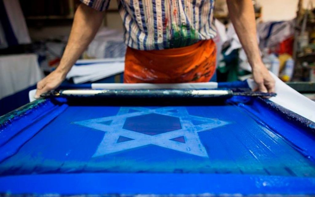 Un artisan qui fabrique un drapeau israélien (Crédit : Flash 90)