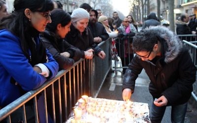 Parmi les participants à la manifestation de ce dimanche 14 février, au 229 boulevard Voltaire, certains agitaient des drapeaux israéliens et d’autres, plus nombreux, tenaient une bougie (Crédit : Times of Israël Staff/Glenn Cloarec)