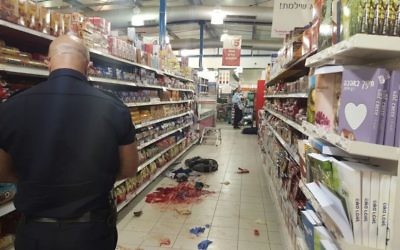 Un policier israélien rassemble des preuves sur les lieux d'une attaque au couteau dans un supermarché dans le parc industriel de Shaar Binyamin, au nord de Jérusalem, le 18 février 2016 (Crédit : Police israélienne) Un policier israélien rassemble des preuves sur les lieux d'une attaque au couteau dans un supermarché dans le parc industriel de Shaar Binyamin, au nord de Jérusalem, le 18 février 2016 (Crédit : Police israélienne)