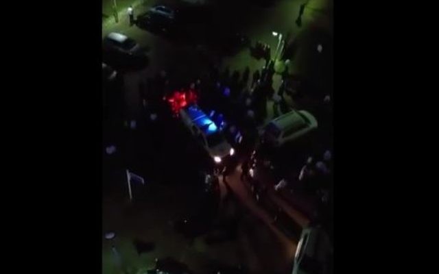 Des émeutiers ultra-orthodoxes encerclent un véhicule de la police après une manifestation contre l'enrôlement dans l'armée, à Ashdod, le 8 février 2016. (Crédit : capture d'écran YouTube) Des émeutiers ultra-orthodoxes encerclent un véhicule de la police après une manifestation contre l'enrôlement dans l'armée, à Ashdod, le 8 février 2016. (Crédit : capture d'écran YouTube)