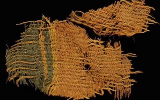 Un beau tissus de laine teint en rouge et bleu. Le tissus utilise les différentes couleurs de poils naturels pour créer des couleurs noir et orange-brun pour les bandes décoratives (Crédit : Clara Amit / Israel Antiquities Authority) Un beau tissus de laine teint en rouge et bleu. Le tissus utilise les différentes couleurs de poils naturels pour créer des couleurs noir et orange-brun pour les bandes décoratives (Crédit : Clara Amit / Israel Antiquities Authority)