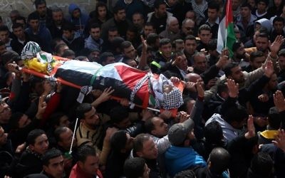 Des Palestiniens en deuil portant le corps d'Amjad Abu Omar Sakari, qui a été abattu en menant une attaque contre des soldats israéliens près de l'implantation de Beit El, lors de ses funérailles dans le village de Jermaine au sud de Naplouse, le 1er Février 2016 (Crédit : AFP / JAAFAR ASHTIYEH)