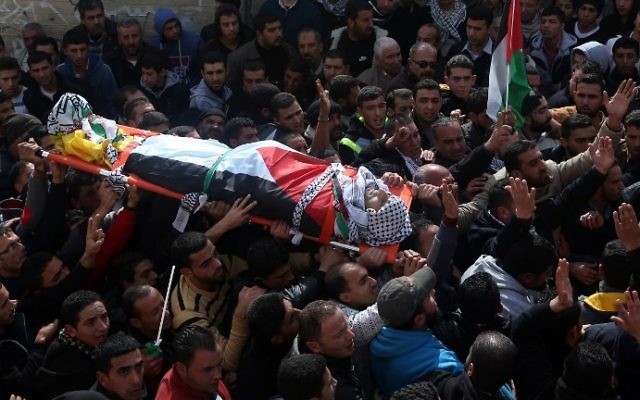 Des Palestiniens en deuil portant le corps d'Amjad Abu Omar Sakari, qui a été abattu en menant une attaque contre des soldats israéliens près de l'implantation de Beit El, lors de ses funérailles dans le village de Jermaine au sud de Naplouse, le 1er Février 2016 (Crédit : AFP / JAAFAR ASHTIYEH)