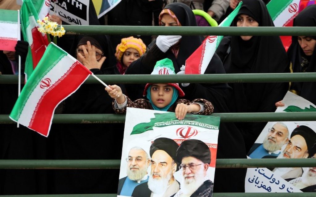 Une jeune fille iranienne tient une affiche avec un portrait du président Hassan Rouhani (à gauche), ledéfunt leader, l'ayatollah Ruhollah Khomeini et l'ayatollah Ali Khamenei, lors des célébrations sur la place Azadi de Téhéran (Place de la Liberté) pour marquer le 37e anniversaire de la révolution islamique le 11 février 2016 (Crédit : AFP / ATTA KENARE) Une jeune fille iranienne tient une affiche avec un portrait du président Hassan Rouhani (à gauche), ledéfunt leader, l'ayatollah Ruhollah Khomeini et l'ayatollah Ali Khamenei, lors des célébrations sur la place Azadi de Téhéran (Place de la Liberté) pour marquer le 37e anniversaire de la révolution islamique le 11 février 2016 (Crédit : AFP / ATTA KENARE)